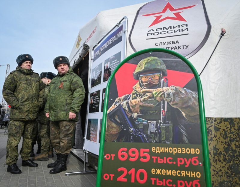 
Krievijas armijas karavīri pie mobilā vervēšanas tablo Krievijā, 2024.gada martā.
